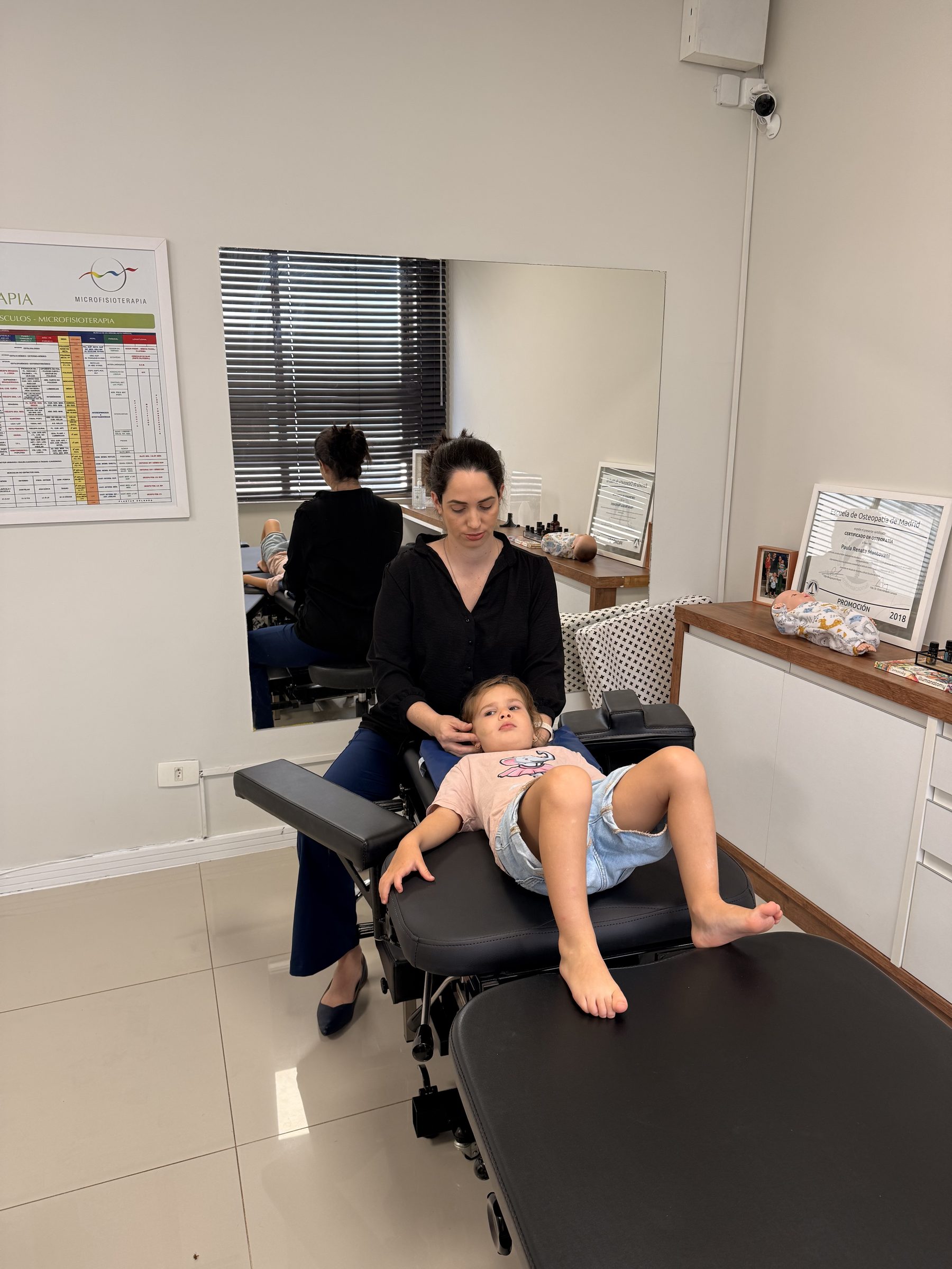 Paula tratando uma criança com osteopatia